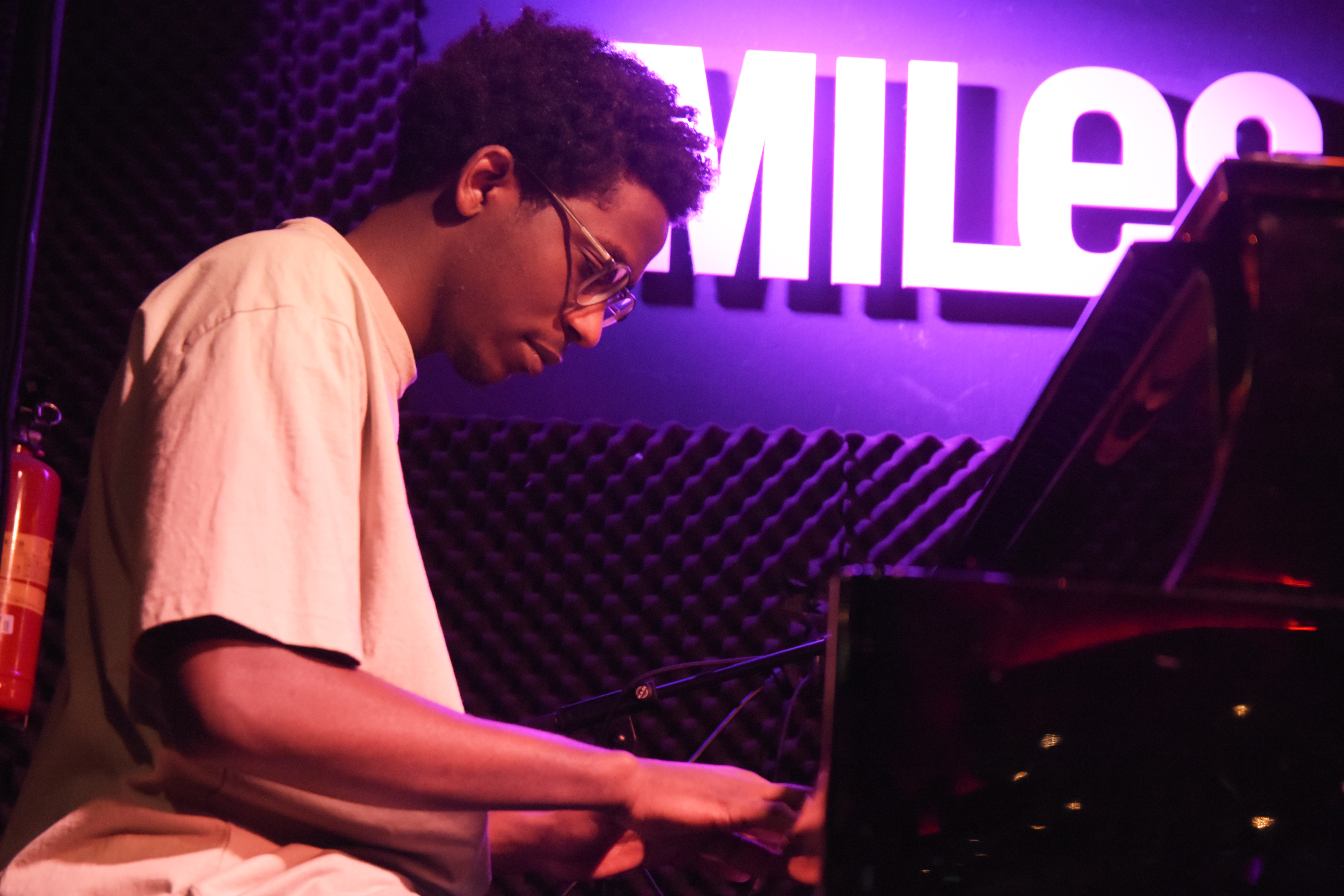 Jonge man speelt piano in cafe Miles