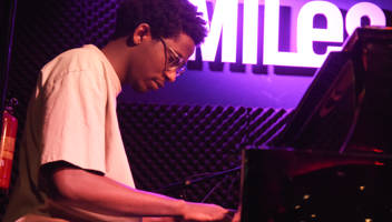 Jonge man speelt piano in cafe Miles