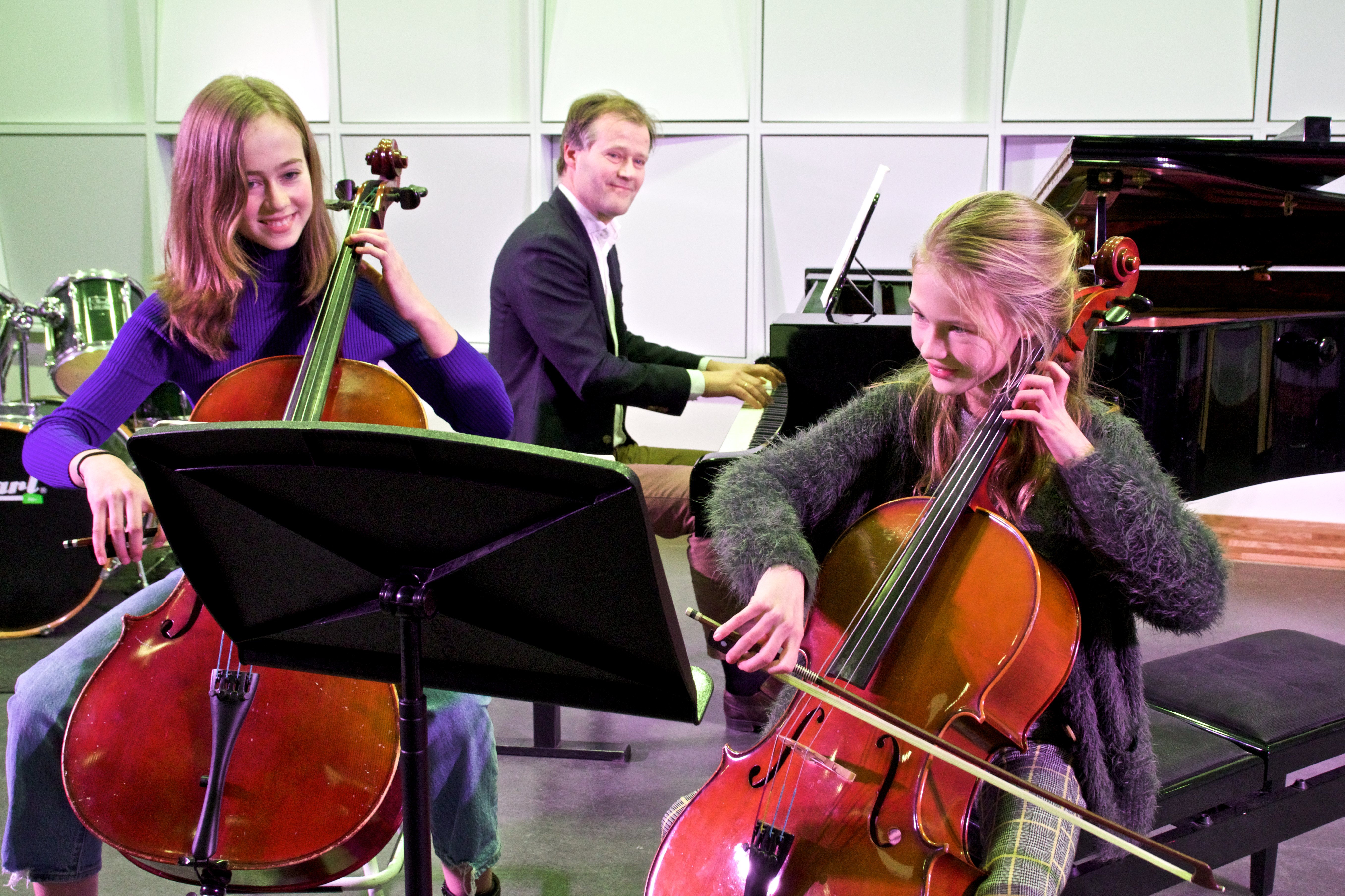Vader speelt piano en zijn dochters spelen cello