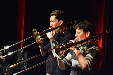 Twee mensen spelen op trombone