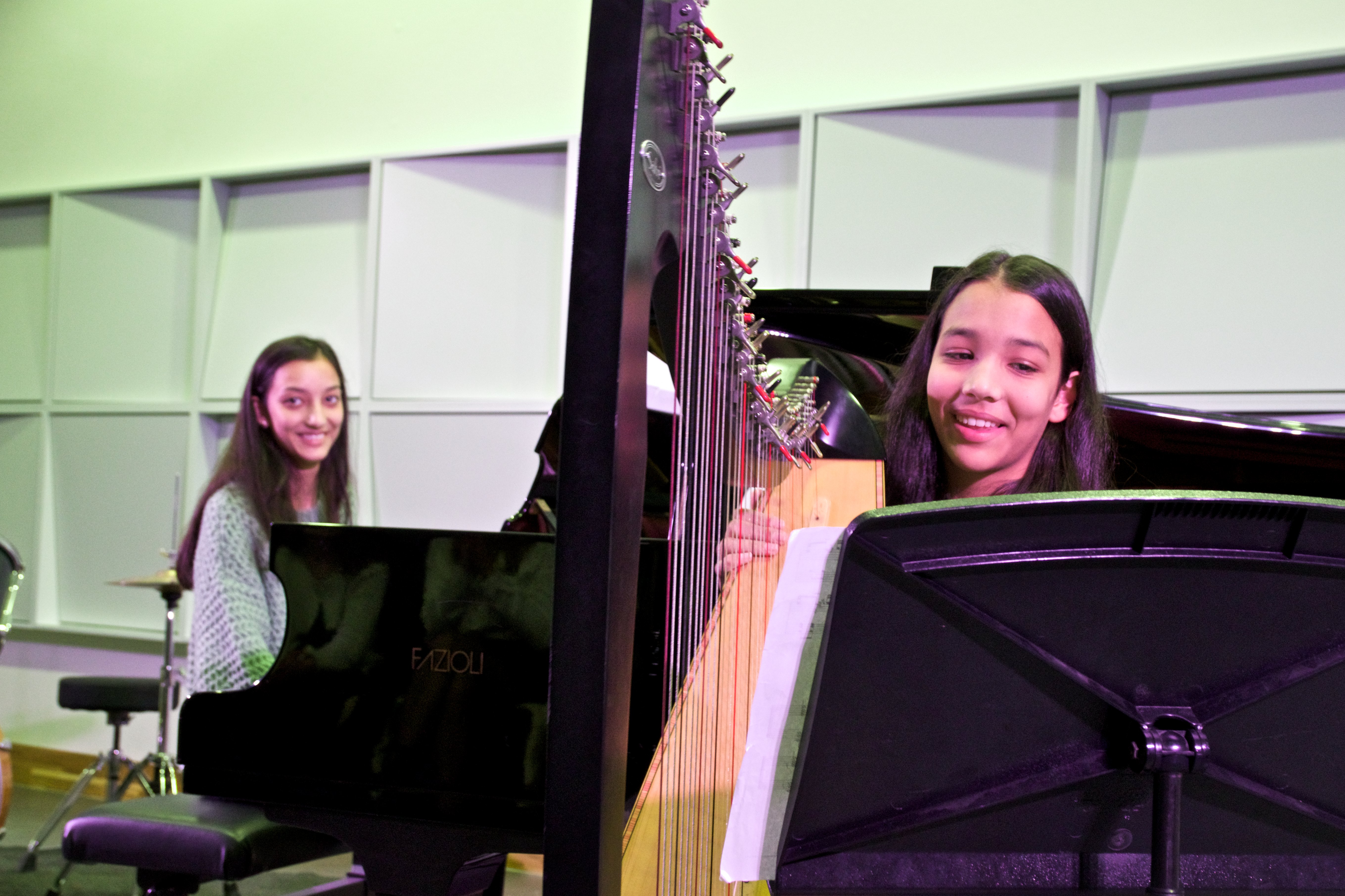 Twee zussen spelen harp en piano