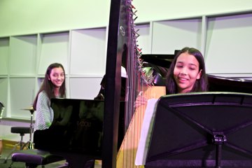 Twee zussen spelen harp en piano